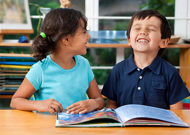 Preschoolers enjoying a book Two delighted kids enjoying a book at school. You may also like: boy and girl reading stock pictures, royalty-free photos & images