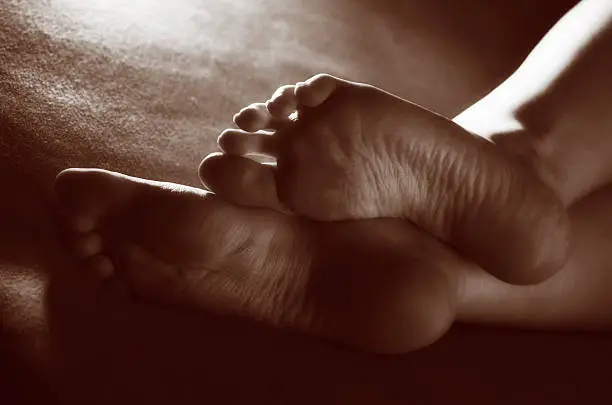 Close-up image of bottom part of female feet. Toned in sepia.