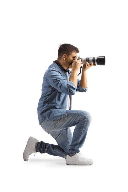 istock Photographer kneeling and taking a photo 1832360163
