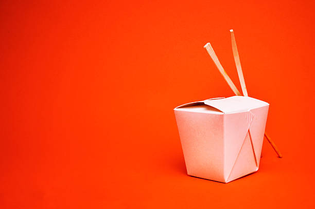 Chinese takeout container with chopsticks, isolated on red Chinese Takeout with room for text. chinese takeout stock pictures, royalty-free photos & images