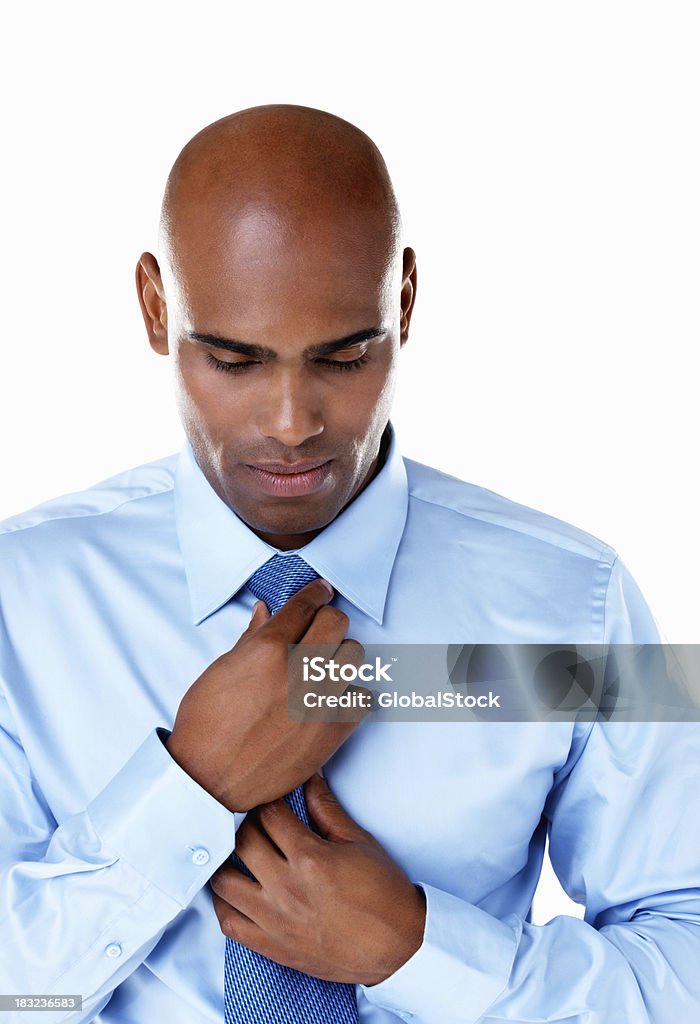 African American business man adjusting tie against white Closeup portrait of an African American business man adjusting tie against white Adjusting Stock Photo