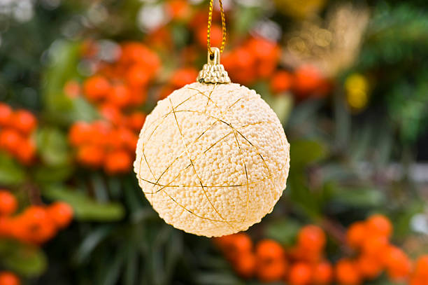 Golden Bauble in Front of Christmas Decoratio stock photo