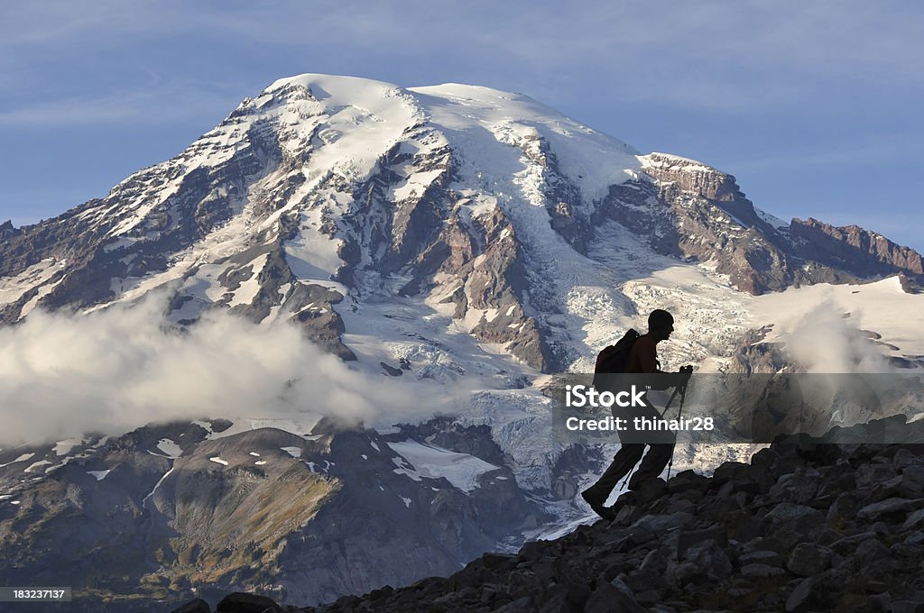 Ascent A silhouetted hiker moving upwards with Mt. Rainier Behind. Endurance Stock Photo