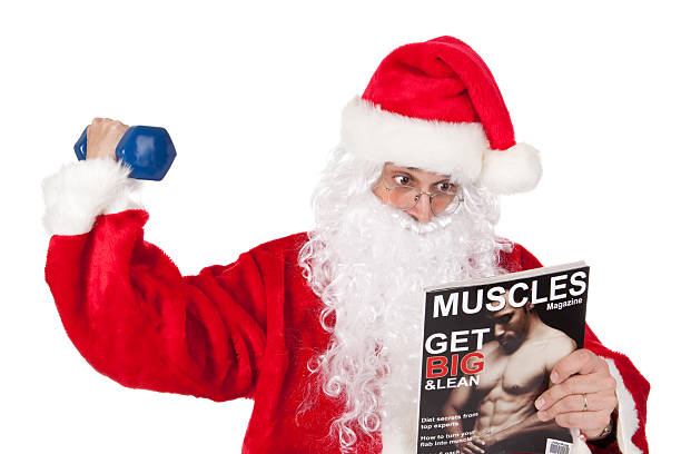Santa tries to beef up as he lifts a weight and reads a muscle magazine.  Magazine was created by photographer.See also: