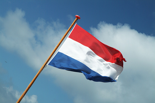 Dutch flag waving in the wind on a sunny day.