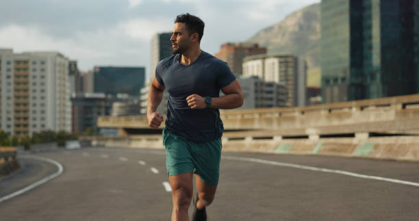 Runner, road or man for fitness in training, sport or exercise goals for marathon competition. Indian athlete, wellness or running challenge in cape town race in progress, city street or health body corredor, corredor u hombre para la forma física en el entrenamiento, el deporte o los objetivos de ejercicio para la competencia de maratón. atleta indio, desafío de bienestar o carrera en ciudad del cabo carrera en curso, calle de la ciudad u organism