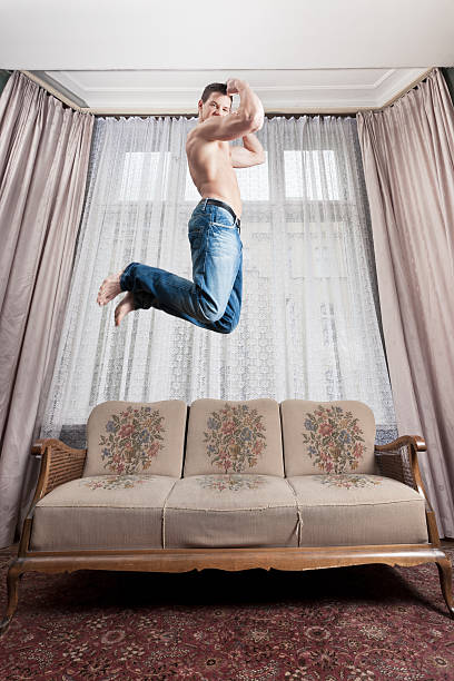 istock Young man jumping, celebrating in hotel room 183240278