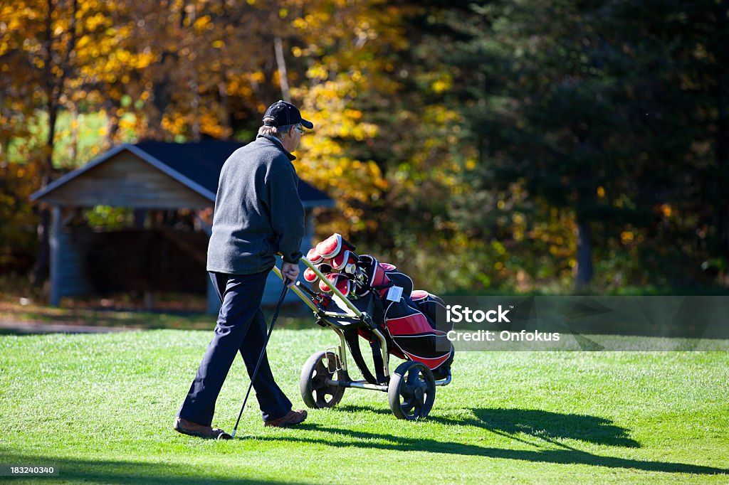 Senior Golf Player en acción en otoño - Foto de stock de 55-59 años libre de derechos