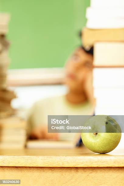 Green Apple Coloca En Un Escritorio Niño En El Fondo Foto de stock y más banco de imágenes de Alimento