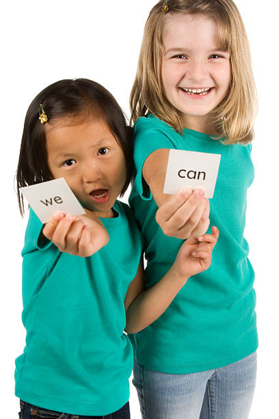 istock Playful girls holding sight word cards 183240939