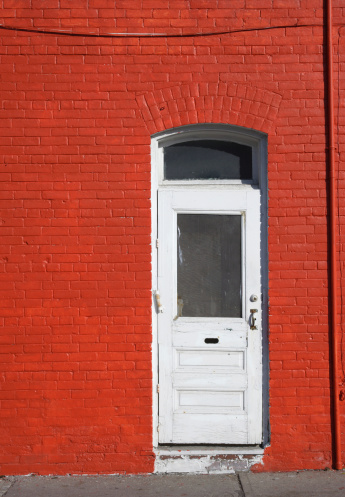 White door  on the bright red brick wall