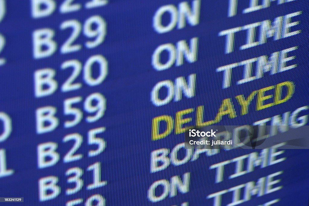 delayed sign at airport board schedule Airport Stock Photo