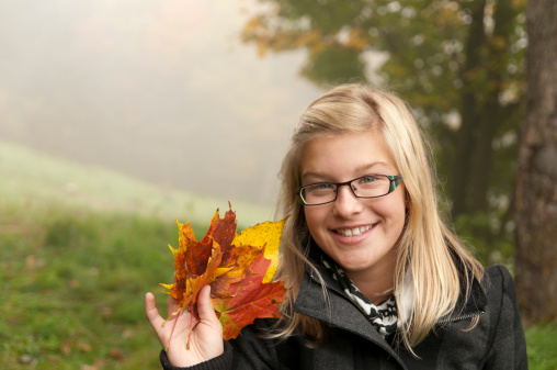 Girl holding colorful fall leaves