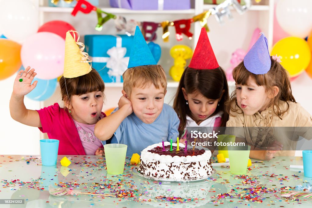 Heureux groupe d'enfants de souffler les bougies sur le gâteau d'anniversaire - Photo de Enfant libre de droits
