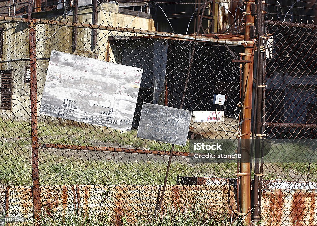 Closed forever A rusty fence prevents entry to an abandoned factory. Abandoned Stock Photo