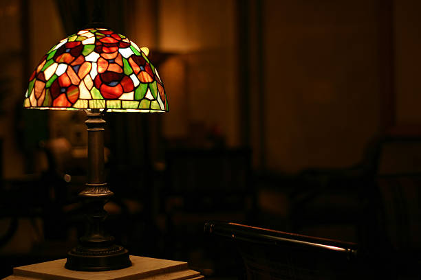 Stained Glass Antique Lamp Stained glass antique lamp in lightly lit room (shallow depth-of-filed). stained glass lamps stock pictures, royalty-free photos & images