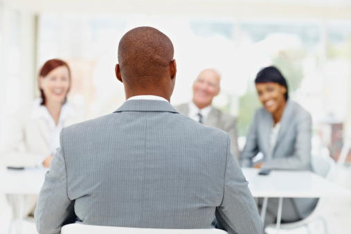 Rear view of an African American man being interviewed by business people