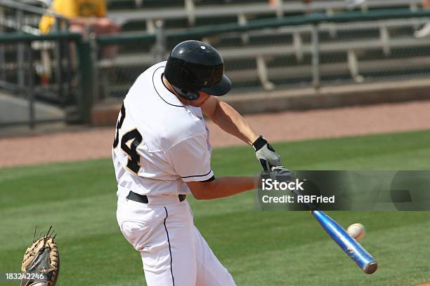 Baseball Player Hitting A Ball With His Bat On The Field Stock Photo - Download Image Now