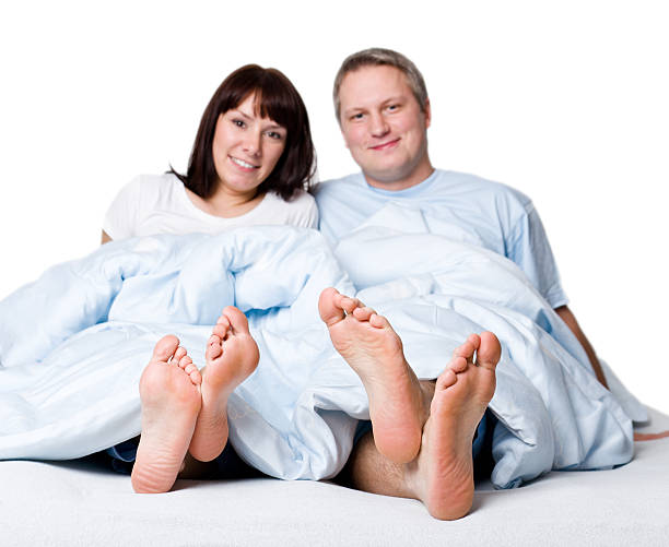 幸せな若いカップルはベッド - bed couple human foot heterosexual couple ストックフォトと画像
