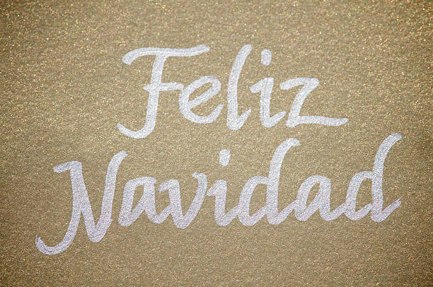 Feliz Navidad message handwritten in silver ink on sparkly textured gold paper