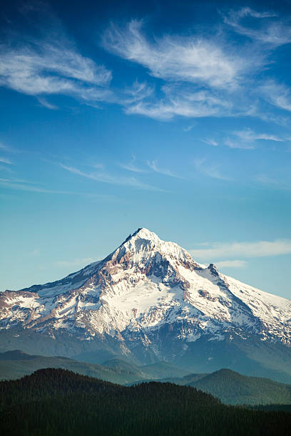 Mount Hood, Oregon State A scenic view of Mt. Hood, and the surrounding hills, a gorgeous cloudscape and blue sky overhead. One of the many beautiful mountains in the Pacific Northwest. Vertical with copy space. mountain peak stock pictures, royalty-free photos & images