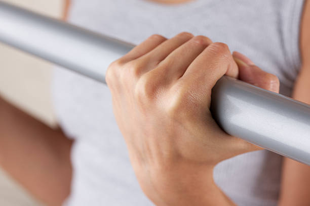 istock Young woman exercising with metal bar 183243824