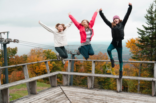 Three happy teenagers jumping on the top of Mont Sutton in fall season. This is from the Sutton-a-lypse 2010.