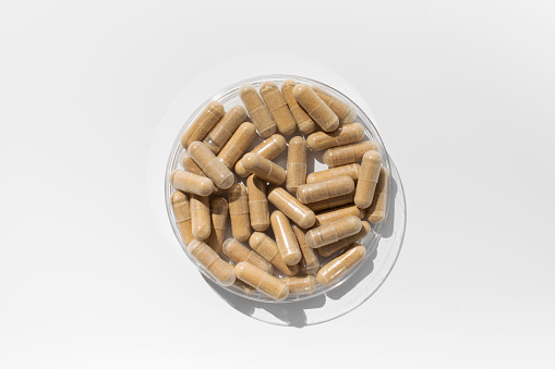 Capsules with vitamins or a dietary supplement are brown on a white background. The concept of medicine, medicines.