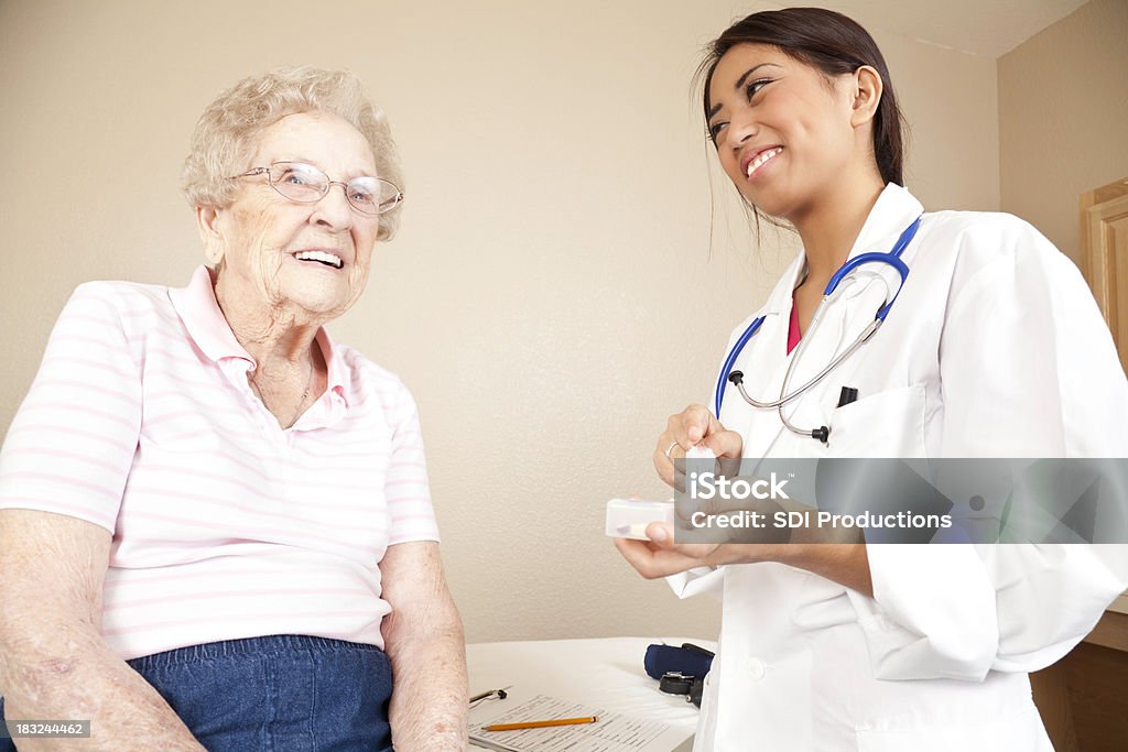 Happy Senior paciente con su joven médico - Foto de stock de Abuela libre de derechos