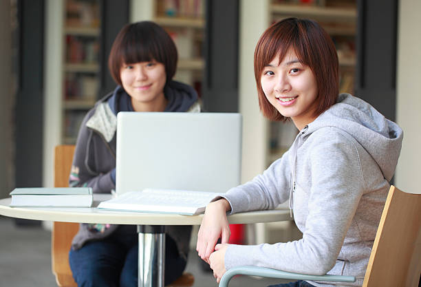 istock two college girl study in the library 183245231