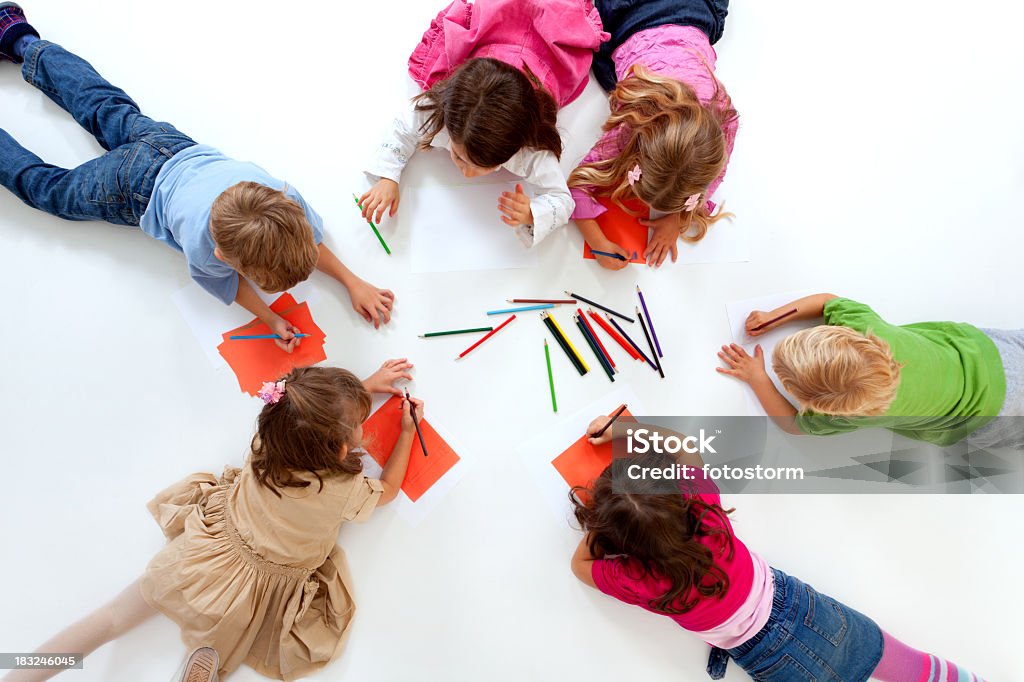 Gruppo di bambini felici sdraiato nel cerchio e disegno - Foto stock royalty-free di Disegnare