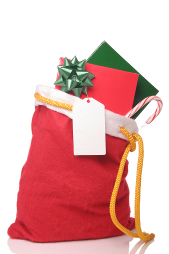 Christmas presents in a red Santa sack. Taken in studio against white background and reflective surface