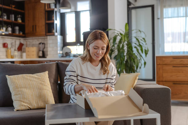 istock Female customer unpacking cardboard box with online order 1832473322