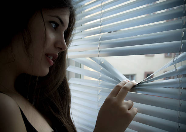 istock Young beauty looking through jalouise 183248259
