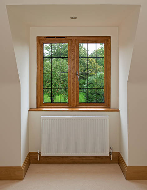 recessed window "A solid mahogany framed leaded light window overlooking a mature garden with apple trees (and red apples...). Set in an expensive luxury new house, this window is recessed into a sloping wall. A white radiator is also featured mounted below the sill.Looking for a window Please see my window collection including cut-outs with clipping paths by clicking on the Lightbox Link below..." window latch stock pictures, royalty-free photos & images