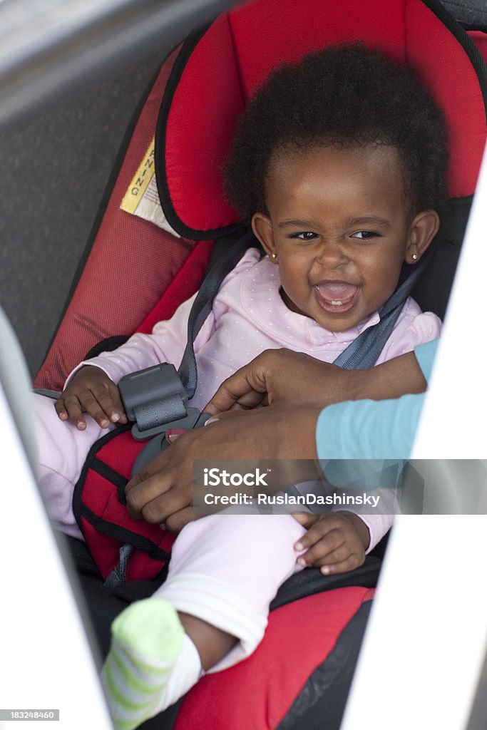 Bebé Feliz niña en un asiento de seguridad. - Foto de stock de Sillita de seguridad de bebés libre de derechos