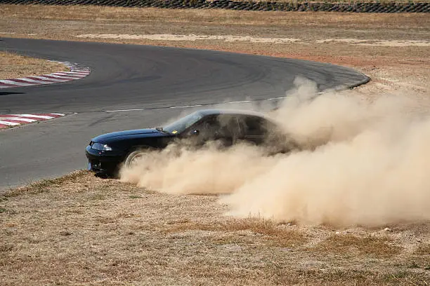 Image 4 of a sequence of action images showing a modified R33 Skyline GTR losing control and spinning out onto the gravel.Image 4 out of 4.