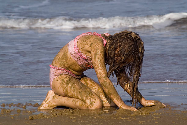 Muddy girl A young girl covered in mud at the beach people covered in mud stock pictures, royalty-free photos & images