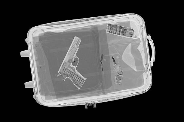 Suitcase with Gun XXL.  Airport x-ray image of a carry-on suitcase with a handgun inside. gchutka stock pictures, royalty-free photos & images