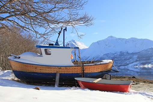 A scenic view of a boat in Arctic fjord in Troms, Norway in winter