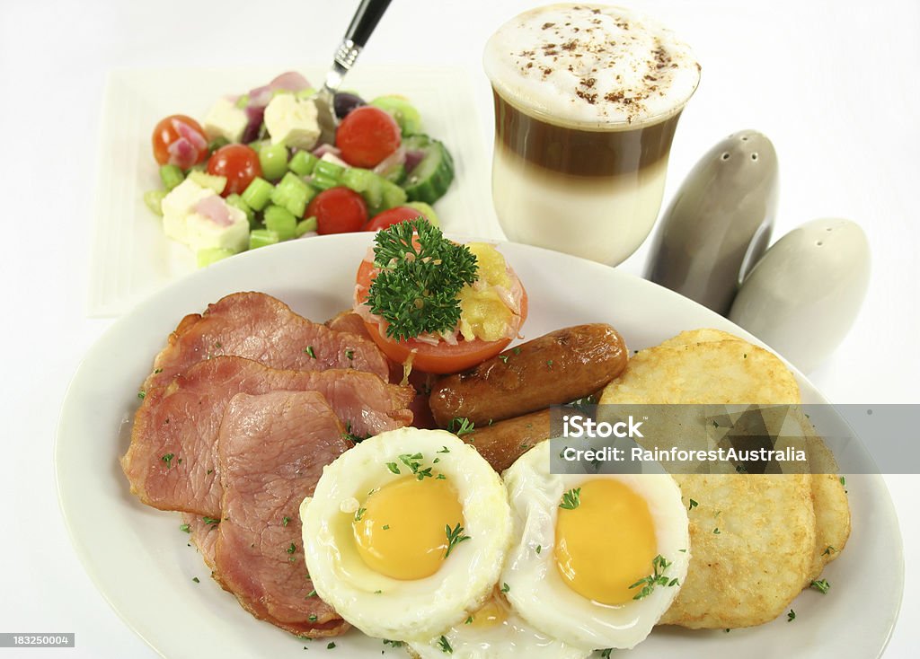 Tocino, huevos, salchichas, tomate, ensalada y un café con leche - Foto de stock de Alimento libre de derechos