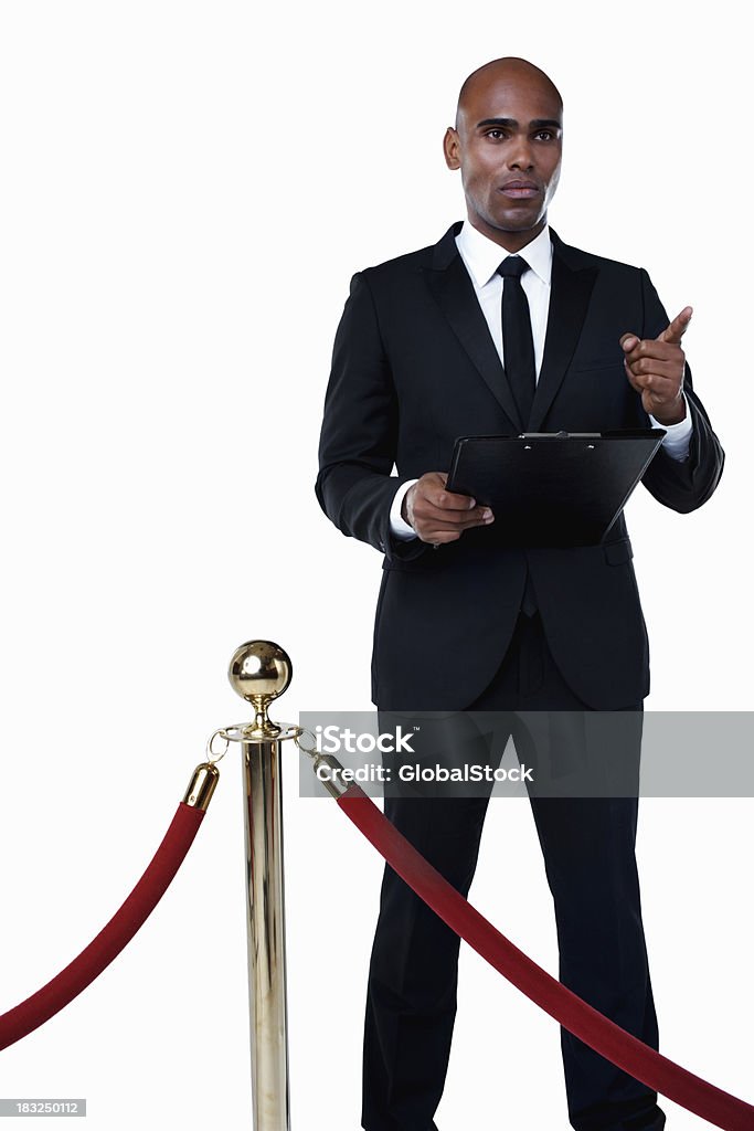 Sicurezza uomo con Appunti in piedi dietro la folla controllo post - Foto stock royalty-free di Buttafuori