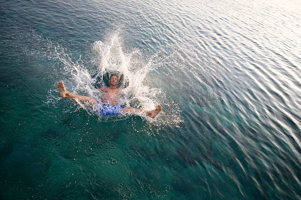 istock Man Falls Splashing into Green Waters 183250147