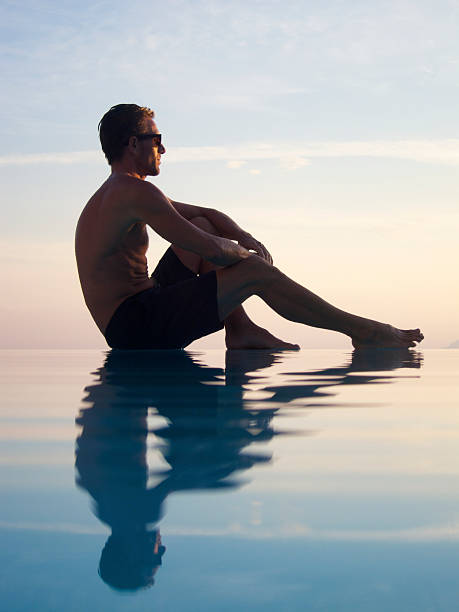 istock Guy Sits Catching Last of the Sun on Infinity Pool 183250213
