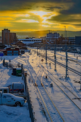 A tranquil winter scene of a train yard at sunset