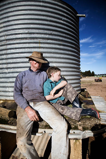 Farmer and Grandson asleep in the sun Hardworking Australian farmer and his grandson having an afternoon nap. sleeping grandpa stock pictures, royalty-free photos & images