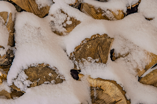 Snow-covered firewood in winter