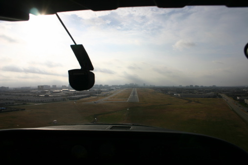 A view out the front of a small airplane while landing.
