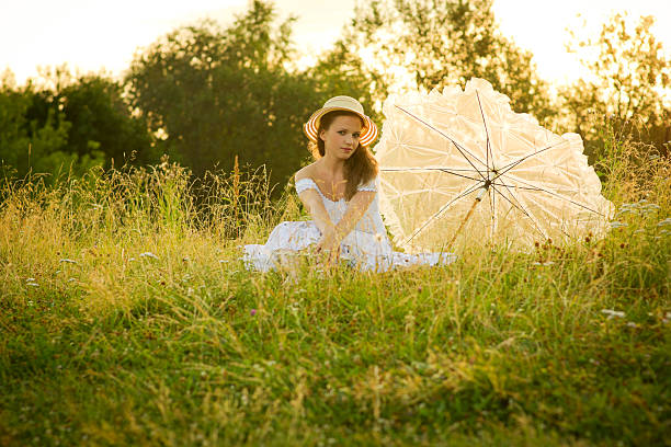 istock Young woman with umbrella under flaring sun 183251584