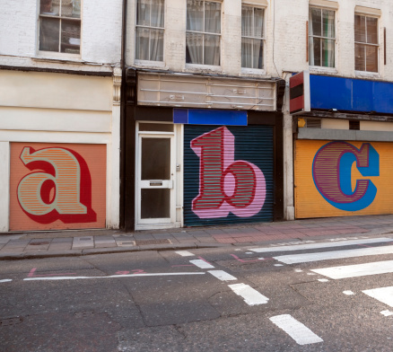 Letters rendered on disused store shutters.